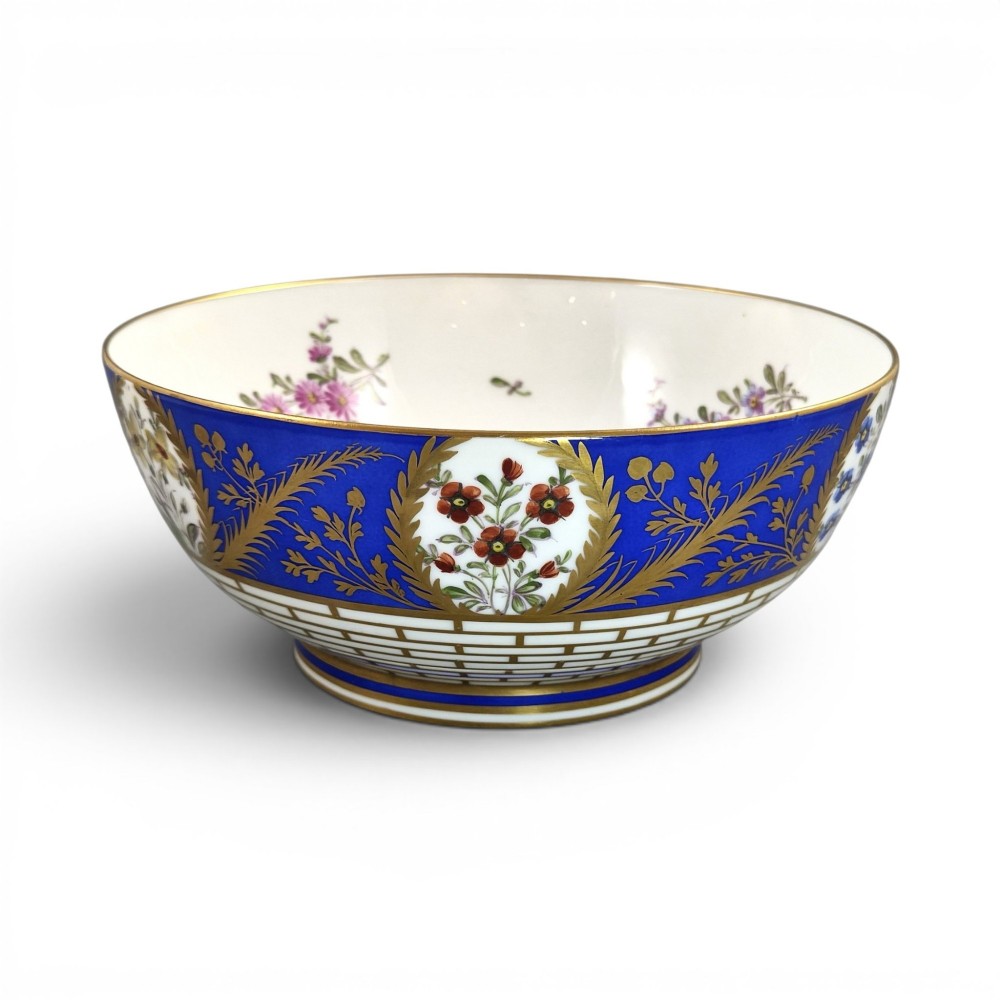 A late 19th-century Samson hard-paste porcelain footed bowl featuring a cobalt blue band with gilded leaf details, hand-painted floral cartouches, and a white brick-patterned base.