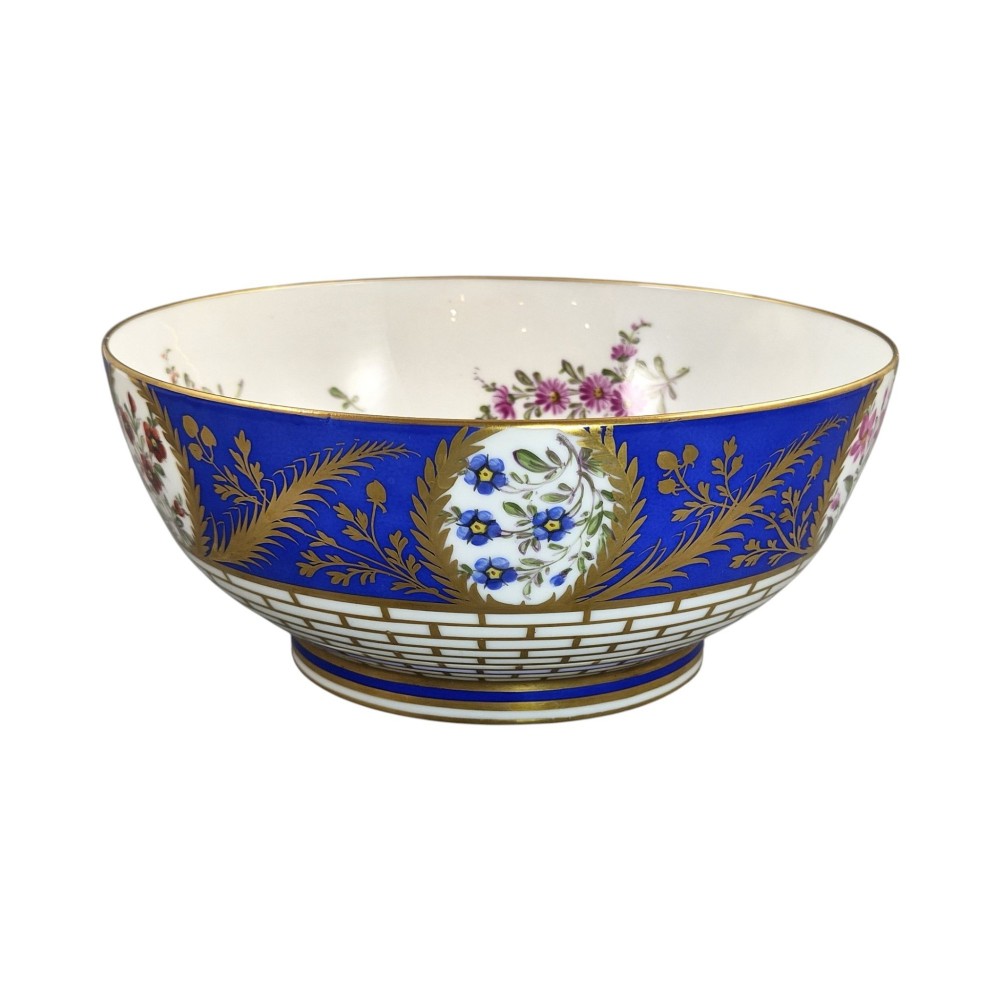 A late 19th-century Samson hard-paste porcelain footed bowl featuring a cobalt blue band with gilded leaf details, hand-painted floral cartouches, and a white brick-patterned base. View V
