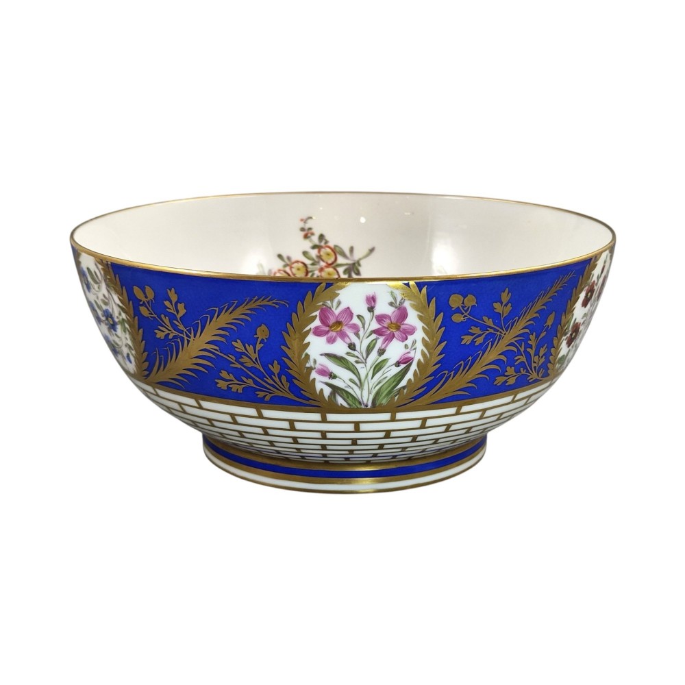 A late 19th-century Samson hard-paste porcelain footed bowl featuring a cobalt blue band with gilded leaf details, hand-painted floral cartouches, and a white brick-patterned base. View VI