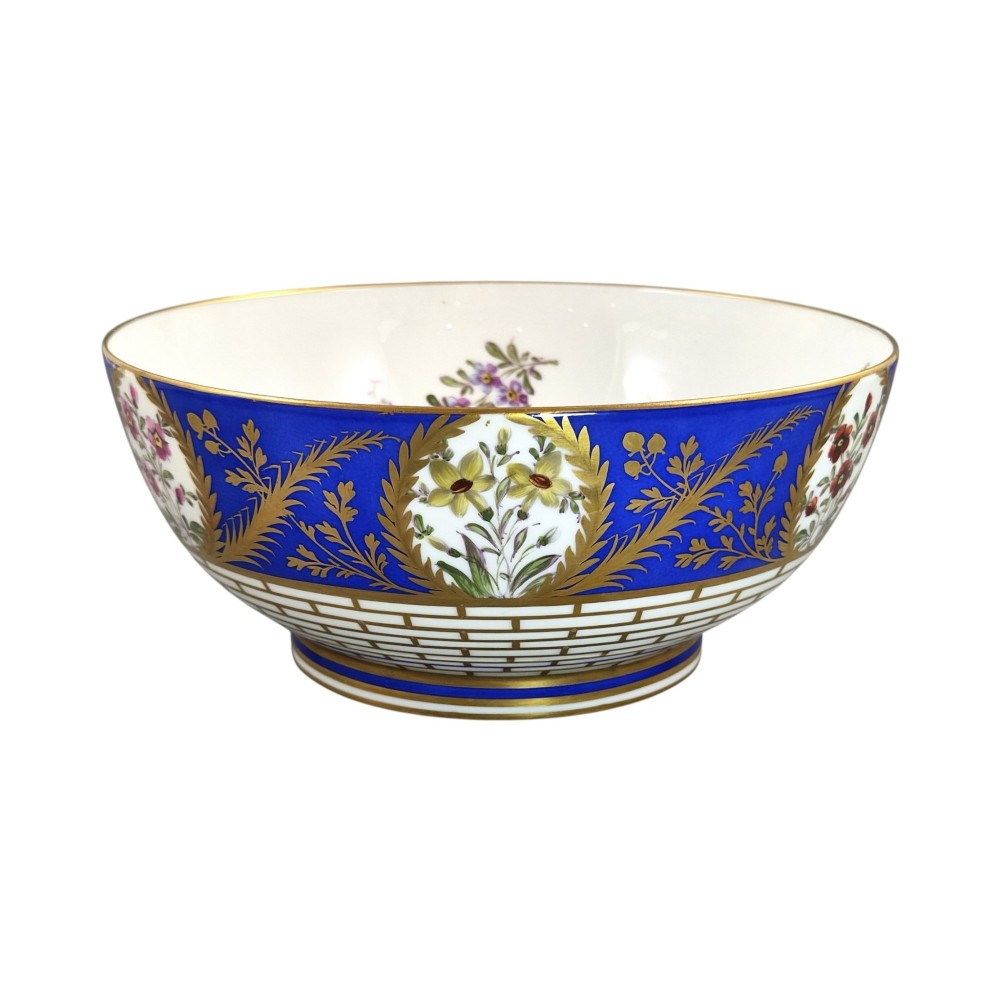 A late 19th-century Samson hard-paste porcelain footed bowl featuring a cobalt blue band with gilded leaf details, hand-painted floral cartouches, and a white brick-patterned base. View IX