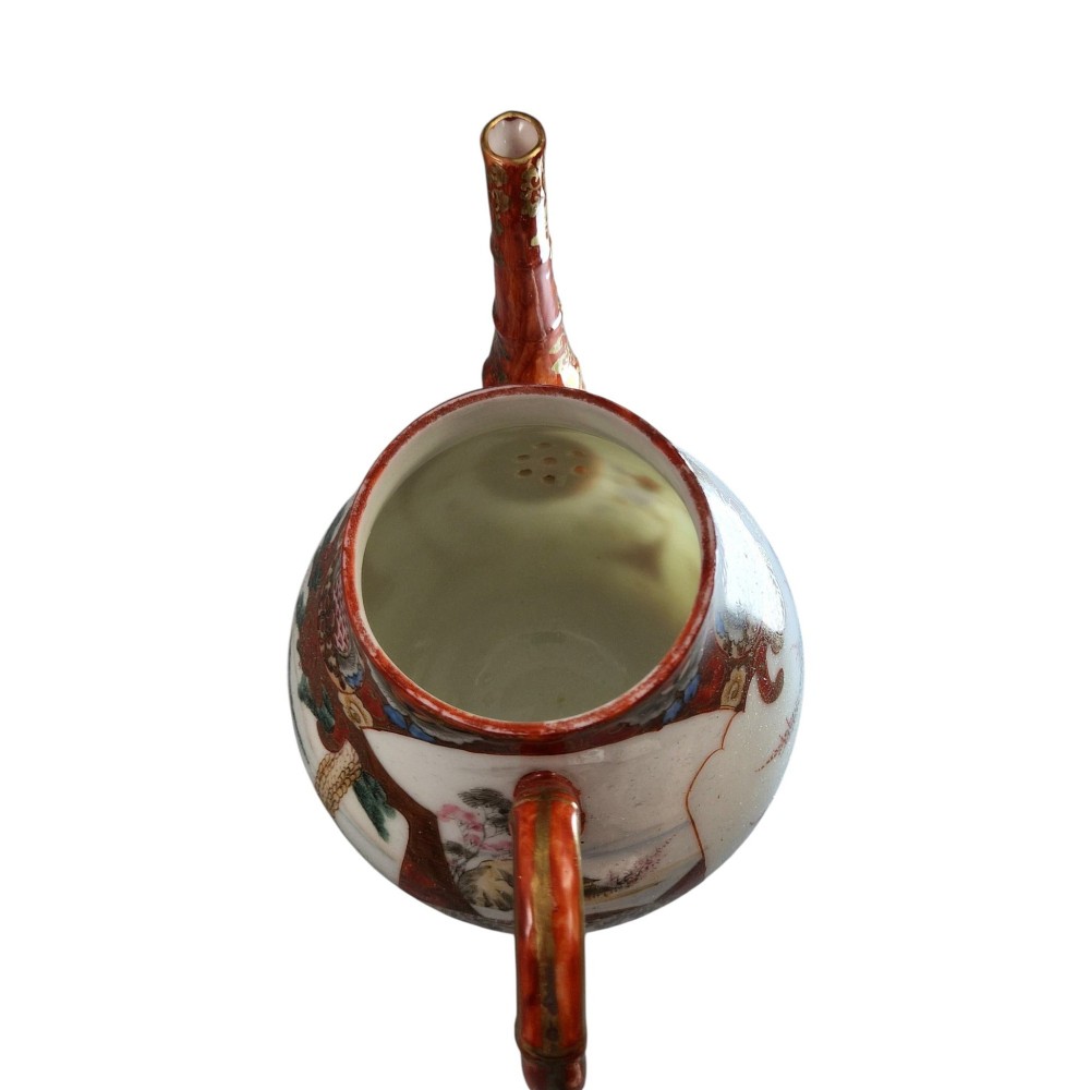 A Japanese Kutani porcelain teapot decorated with iron-red enamel, gilded accents, and hand-painted figurative scenes, seated on a matching pedestal stand. View VII