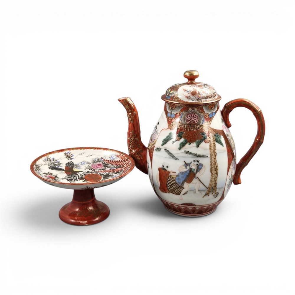 A Japanese Kutani porcelain teapot decorated with iron-red enamel, gilded accents, and hand-painted figurative scenes, seated on a matching pedestal stand. View XIV