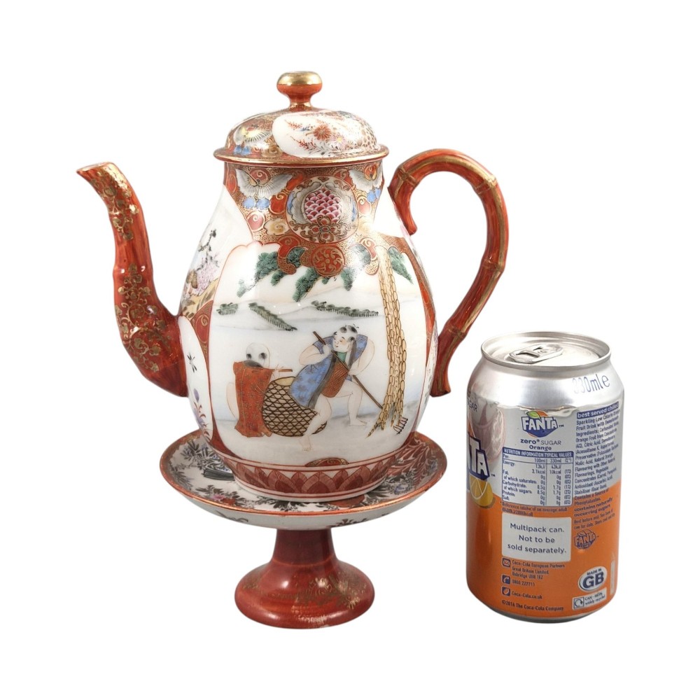 A Japanese Kutani porcelain teapot decorated with iron-red enamel, gilded accents, and hand-painted figurative scenes, seated on a matching pedestal stand. View XV