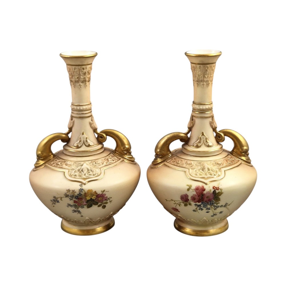A symmetrical pair of Edwardian Royal Worcester blush ivory porcelain vases featuring gilded dolphin handles, relief-moulded necks, and hand-painted floral decoration. View III