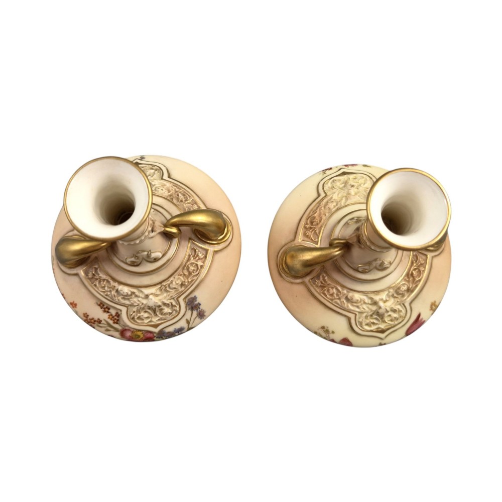 A symmetrical pair of Edwardian Royal Worcester blush ivory porcelain vases featuring gilded dolphin handles, relief-moulded necks, and hand-painted floral decoration. View VI