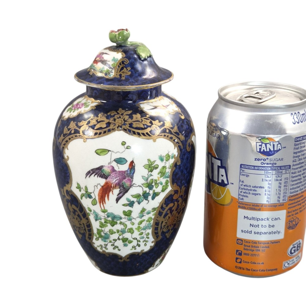 An Edwardian covered ceramic vase featuring a dark scale blue ground with gilded rococo cartouches framing painted floral panels. View XI