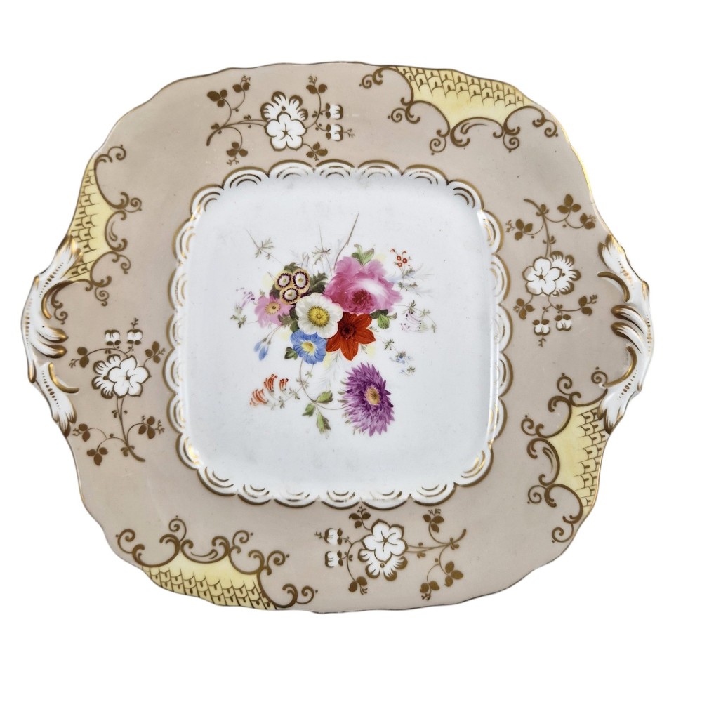 A pair of early Victorian Coalport porcelain square dessert dishes featuring hand-painted floral centres, beige borders with gold scrollwork, and moulded twin handles. View IV