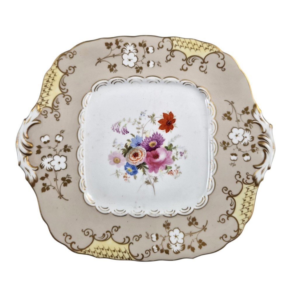 A pair of early Victorian Coalport porcelain square dessert dishes featuring hand-painted floral centres, beige borders with gold scrollwork, and moulded twin handles. View VII