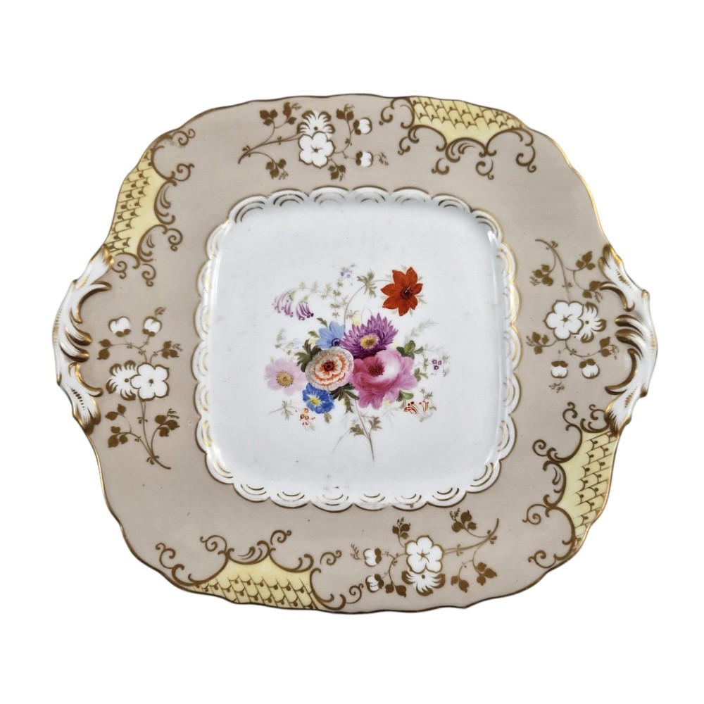 A pair of early Victorian Coalport porcelain square dessert dishes featuring hand-painted floral centres, beige borders with gold scrollwork, and moulded twin handles. View VIII
