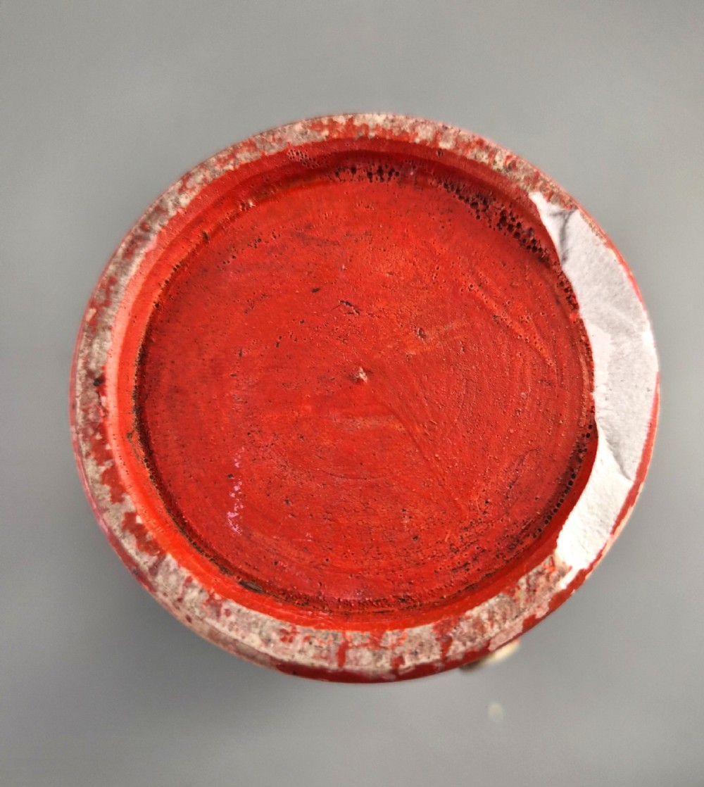 A tall Japanese Sumida Gawa ceramic vase featuring a ribbed red base, applied relief figures of sages on a cliff, and a heavy dark drip glaze around the rim. View XI