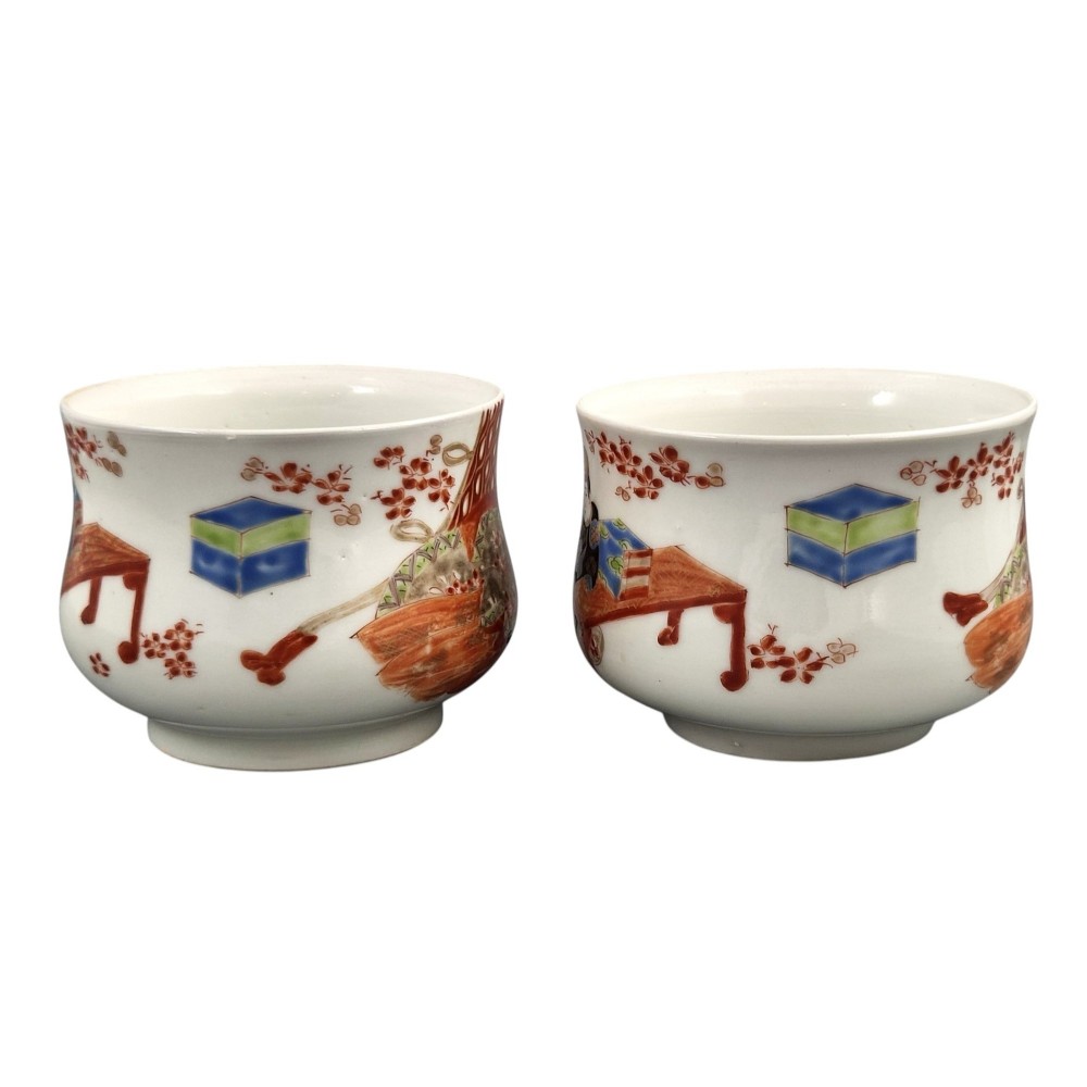 A pair of late 19th-century white Japanese Imari porcelain handleless sencha teacups hand-painted with figures at low desks and floral motifs in iron red and black enamels. View II