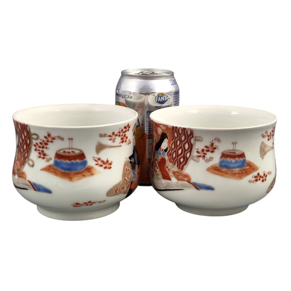 A pair of late 19th-century white Japanese Imari porcelain handleless sencha teacups hand-painted with figures at low desks and floral motifs in iron red and black enamels. View V
