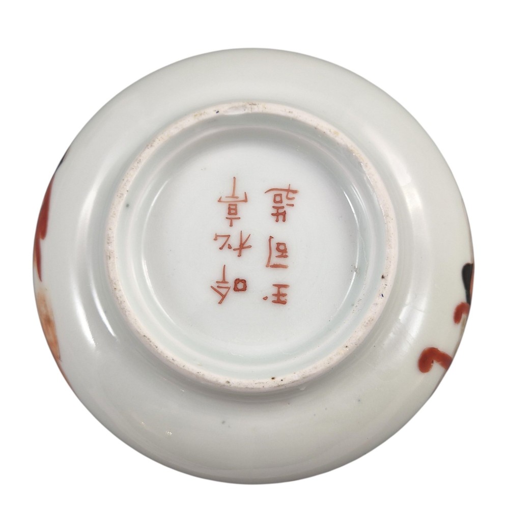 A pair of late 19th-century white Japanese Imari porcelain handleless sencha teacups hand-painted with figures at low desks and floral motifs in iron red and black enamels. View IX