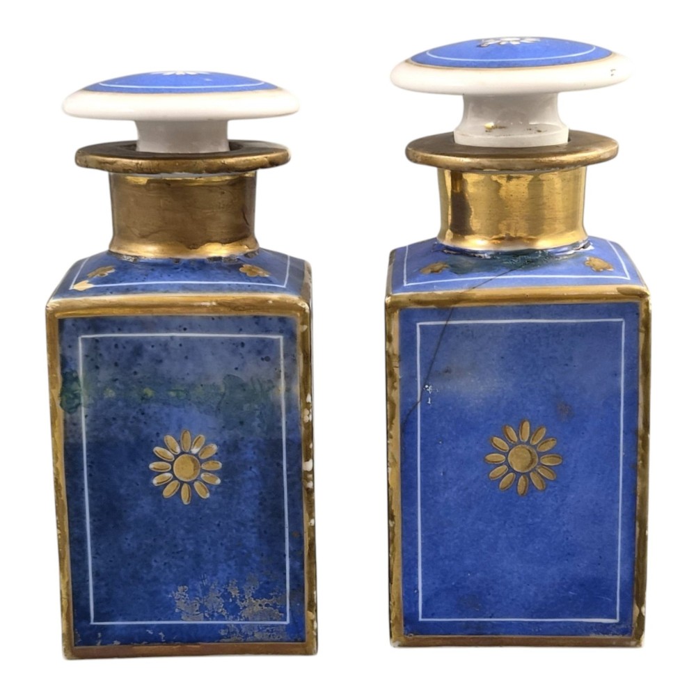 A pair of square 19th-century French porcelain perfume bottles featuring cobalt blue tops, gilded necks, and hand-painted genre scenes of figures in tavern settings. View II