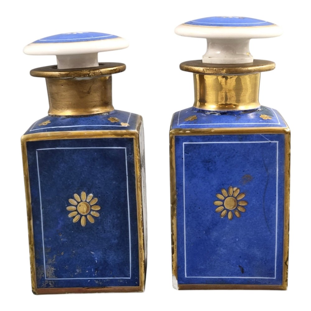 A pair of square 19th-century French porcelain perfume bottles featuring cobalt blue tops, gilded necks, and hand-painted genre scenes of figures in tavern settings. View VII