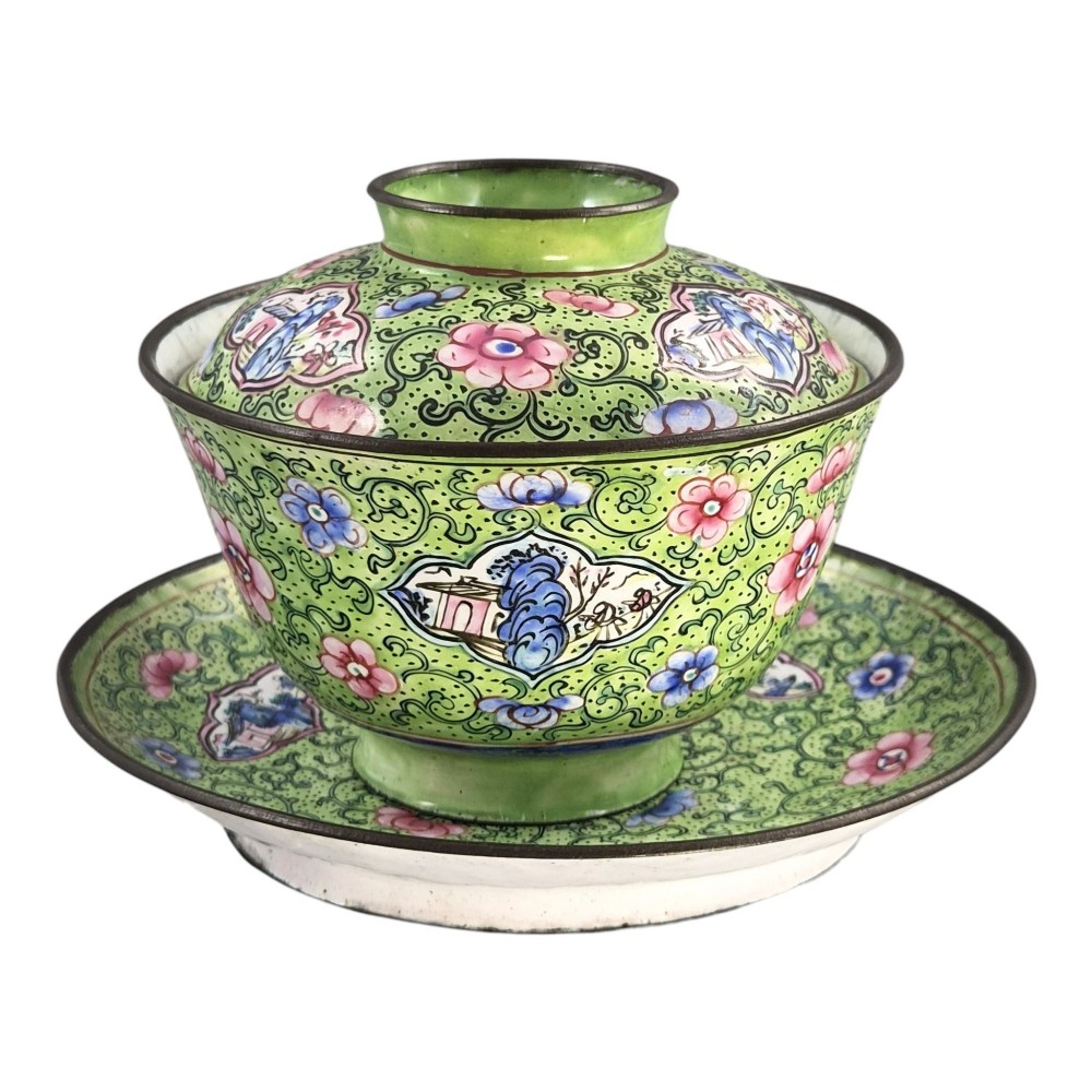 A Chinese Canton enamel gaiwan featuring a green ground with pink floral scrolls and landscape cartouches, complete with lid and matching saucer. View II