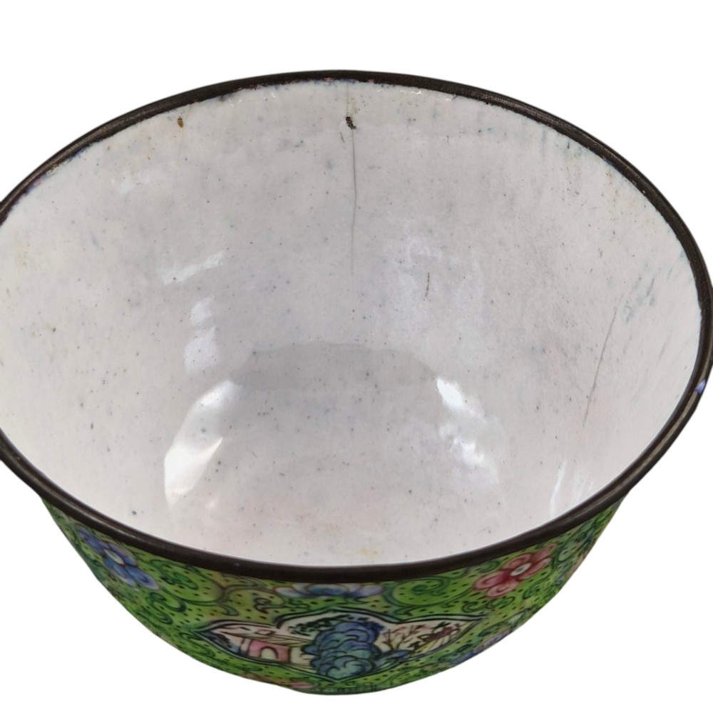A Chinese Canton enamel gaiwan featuring a green ground with pink floral scrolls and landscape cartouches, complete with lid and matching saucer. View XIV