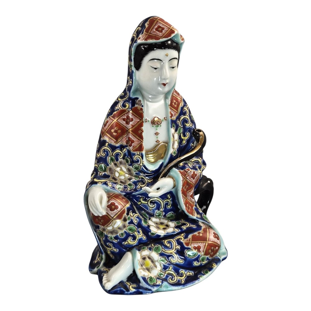 A seated Japanese Arita porcelain figure depicting Jigoku Dayu wearing a patterned blue, red, and gold hooded robe. View VII