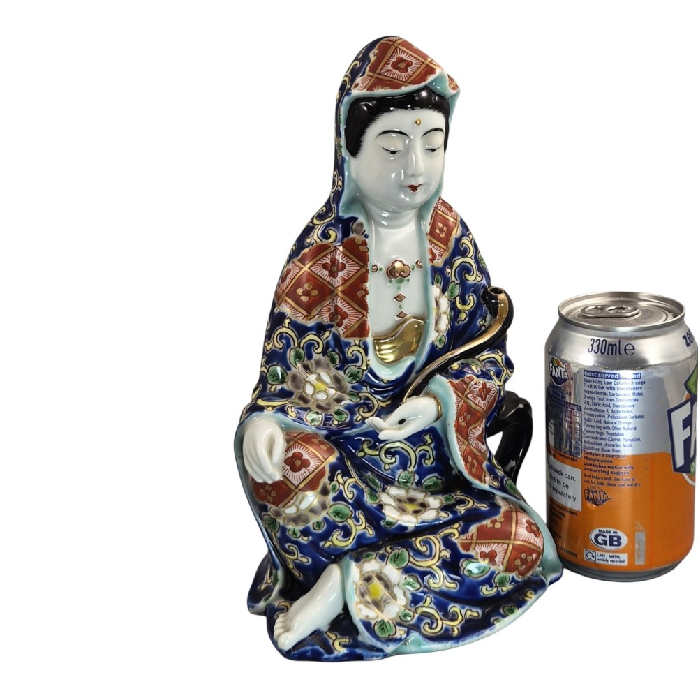A seated Japanese Arita porcelain figure depicting Jigoku Dayu wearing a patterned blue, red, and gold hooded robe. View VIII