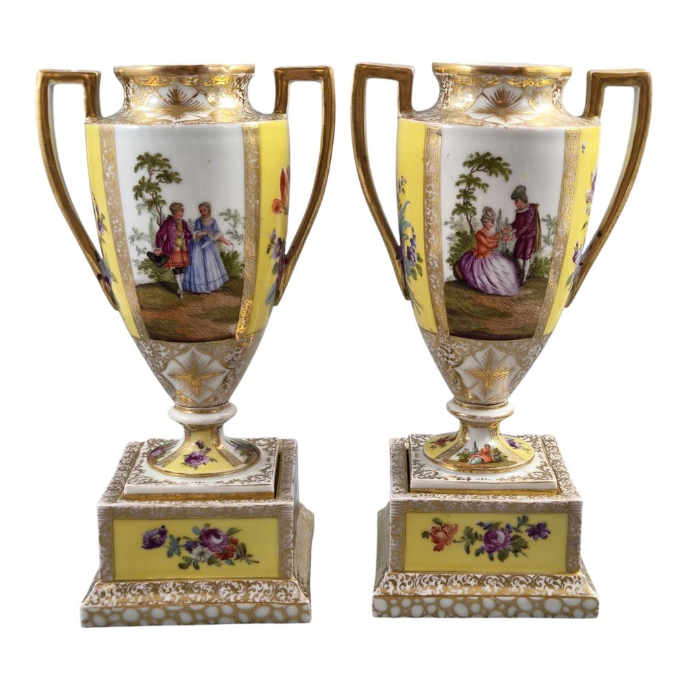 A pair of late nineteenth-century Dresden porcelain urns featuring yellow ground, hand-painted romantic scenes, gilded handles, and square pedestal bases. View III
