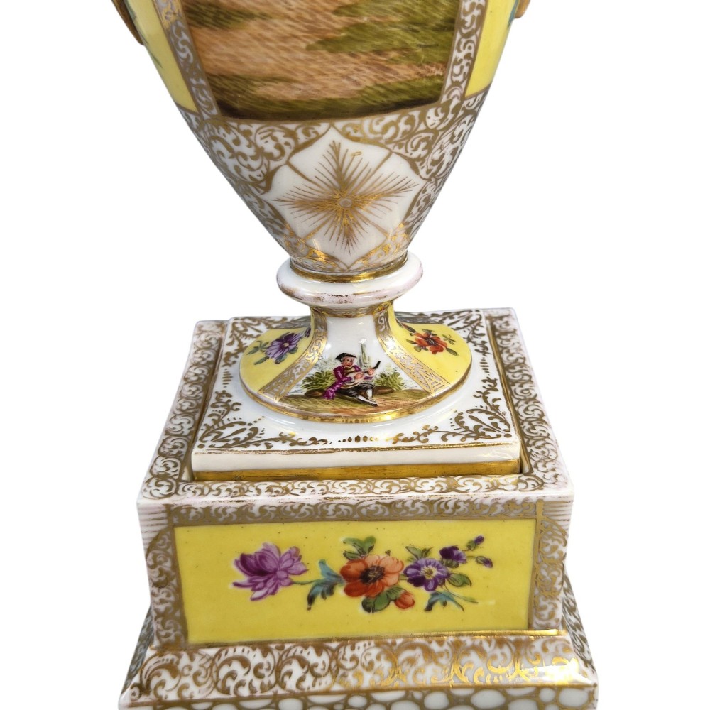 A pair of late nineteenth-century Dresden porcelain urns featuring yellow ground, hand-painted romantic scenes, gilded handles, and square pedestal bases. View XI