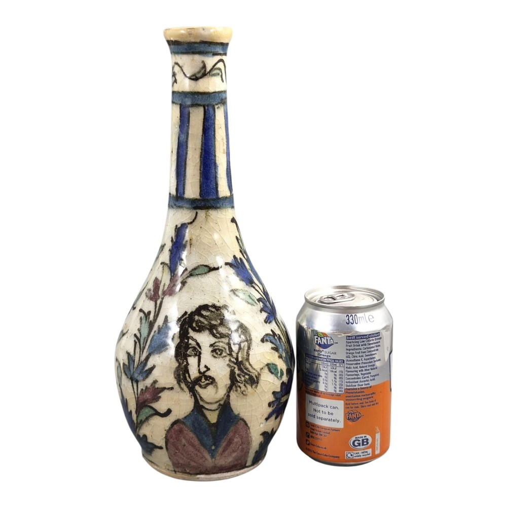 An Iranian Qajar ceramic bottle vase featuring an elongated neck, cream crackle glaze, and hand-painted blue and purple figurative portrait and floral motifs. View IX