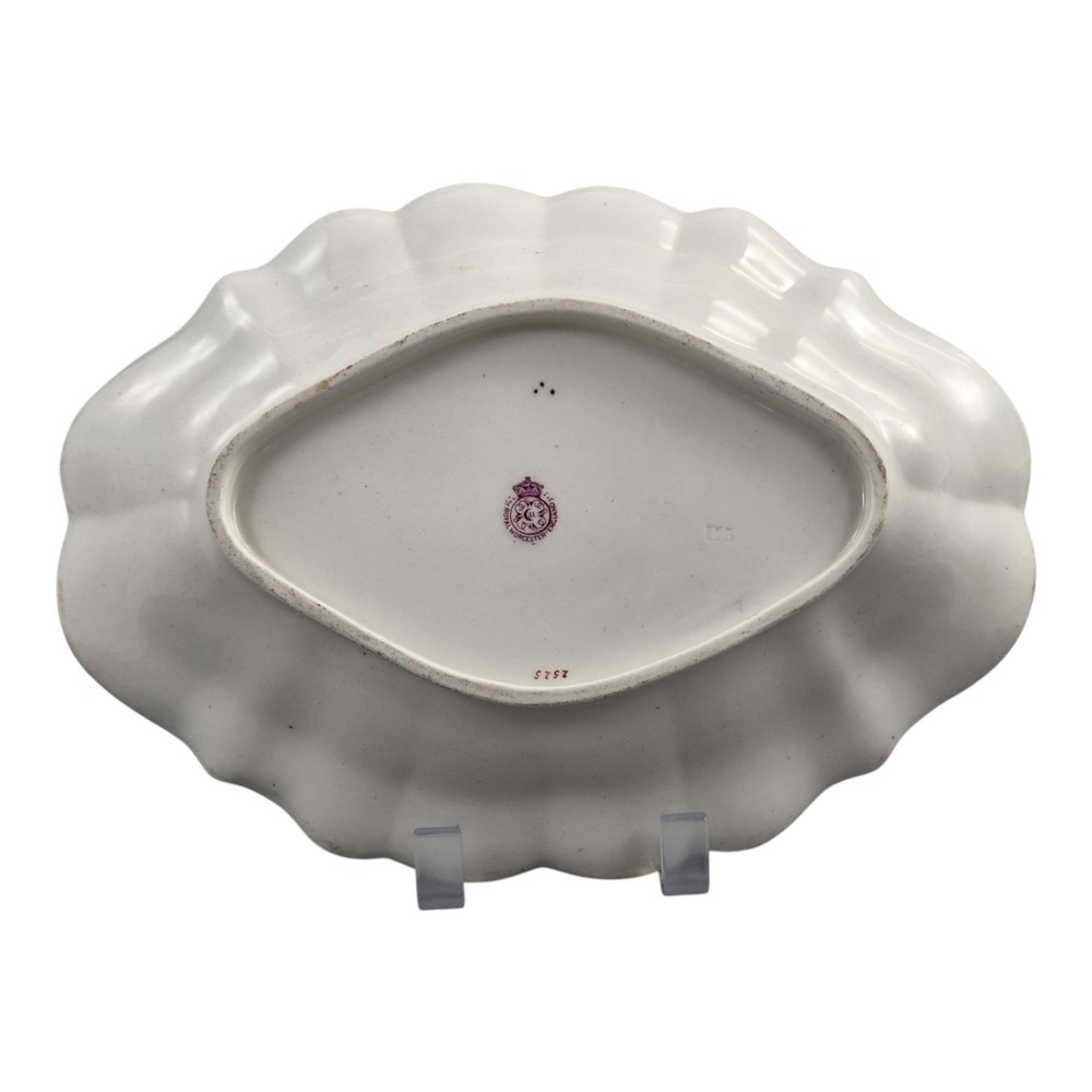 An oval scalloped porcelain dessert dish featuring a deep blue scale ground pattern with gilt-framed reserves containing hand-painted exotic birds and insects. View IV