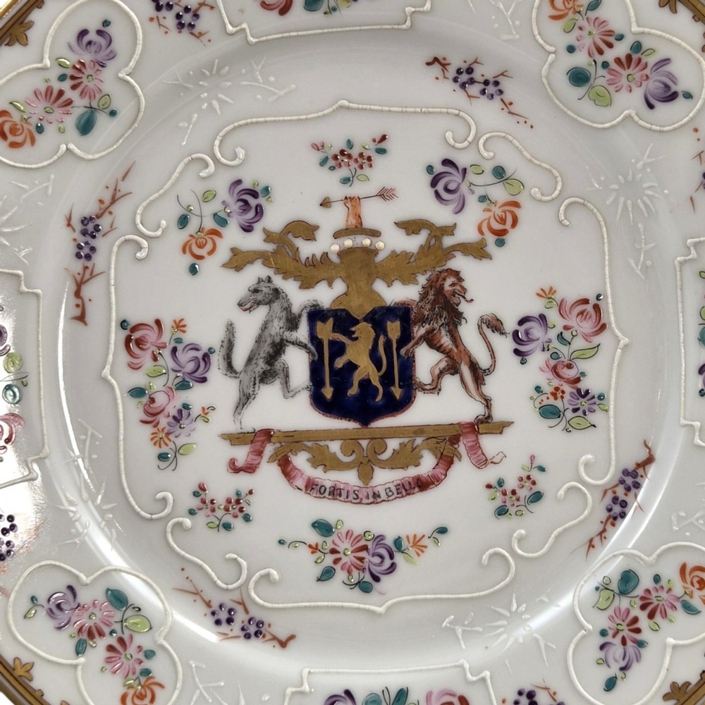 A pair of circular white porcelain plates featuring a central coat of arms, hand-painted floral sprays, raised enamel details, and gilded rims. View VII