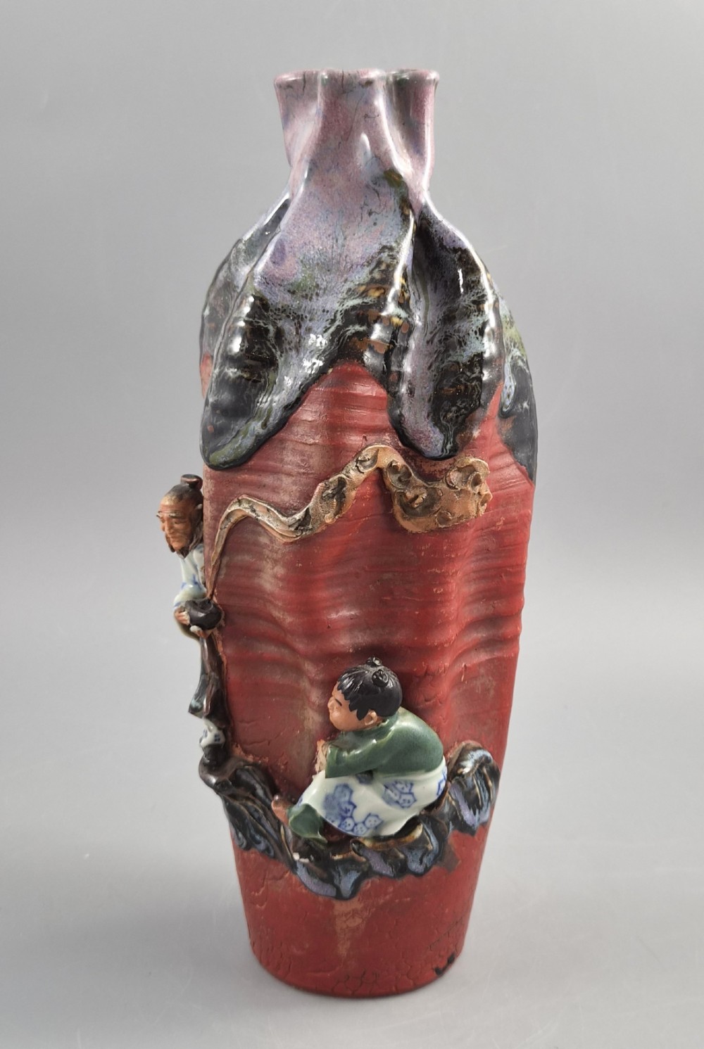 A Japanese Sumida Gawa terracotta vase with applied high-relief figures of a sage and child beneath a dripping lavender and dark flambe glaze. View III
