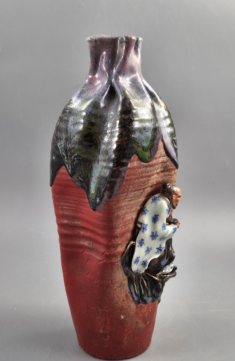 A Japanese Sumida Gawa terracotta vase with applied high-relief figures of a sage and child beneath a dripping lavender and dark flambe glaze. View VII