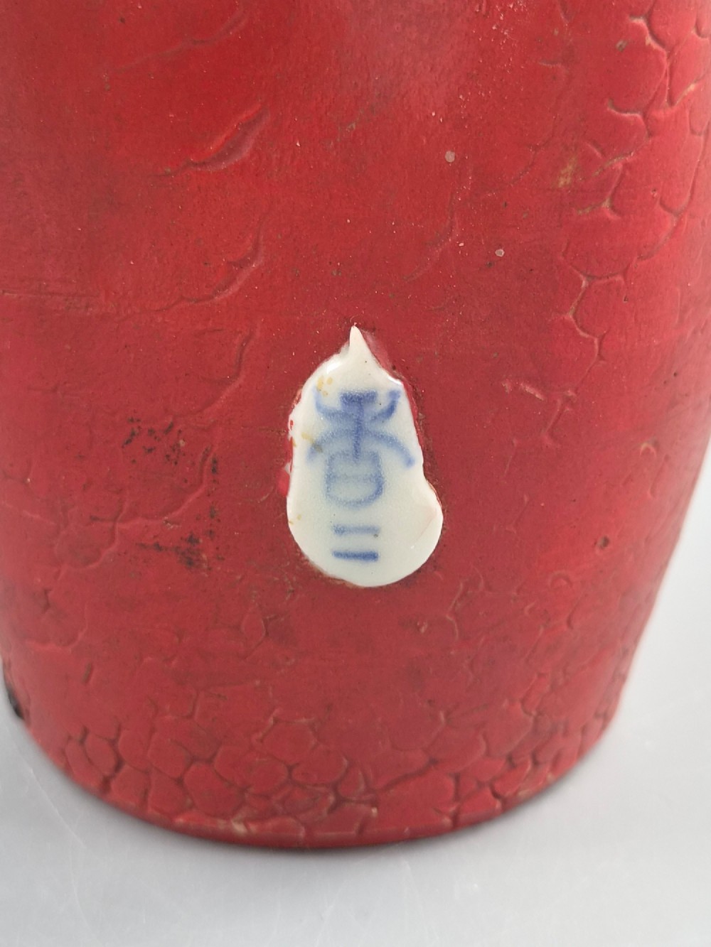 A Japanese Sumida Gawa terracotta vase with applied high-relief figures of a sage and child beneath a dripping lavender and dark flambe glaze. View X