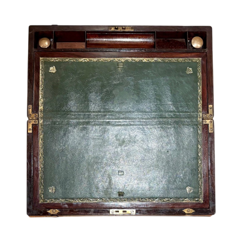 An open Victorian mahogany writing slope featuring flush brass corner bindings, internal pen compartments, and a green gilt-tooled leather writing surface. View II