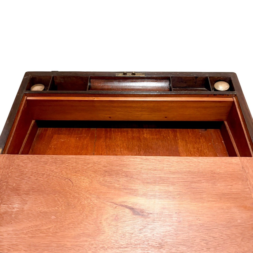 An open Victorian mahogany writing slope featuring flush brass corner bindings, internal pen compartments, and a green gilt-tooled leather writing surface. View VI