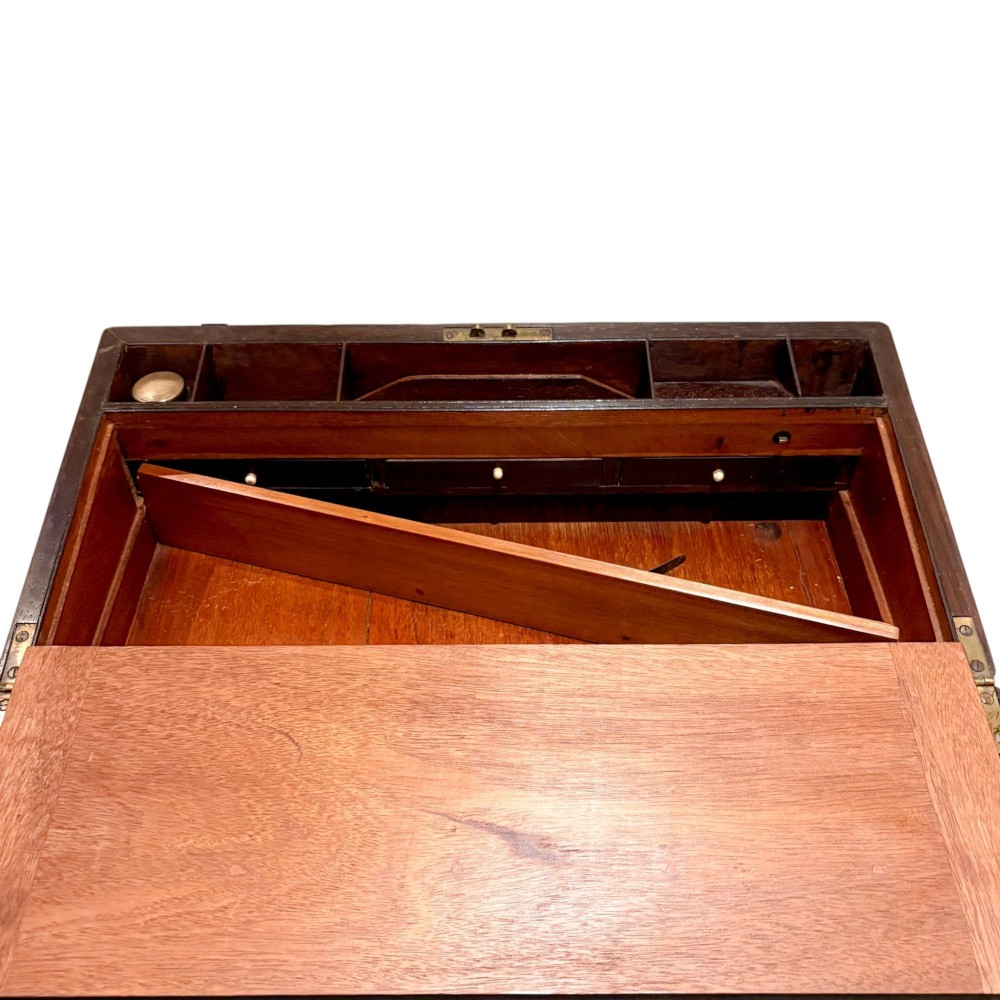 An open Victorian mahogany writing slope featuring flush brass corner bindings, internal pen compartments, and a green gilt-tooled leather writing surface. View VIII