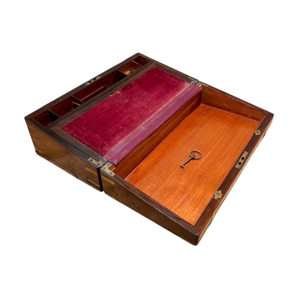 A closed rectangular Victorian rosewood writing slope featuring brass strapping, brass corner mounts, and a central brass escutcheon. View IV