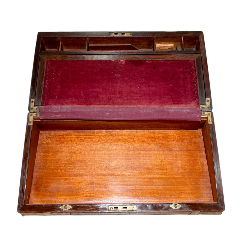 A closed rectangular Victorian rosewood writing slope featuring brass strapping, brass corner mounts, and a central brass escutcheon. View V