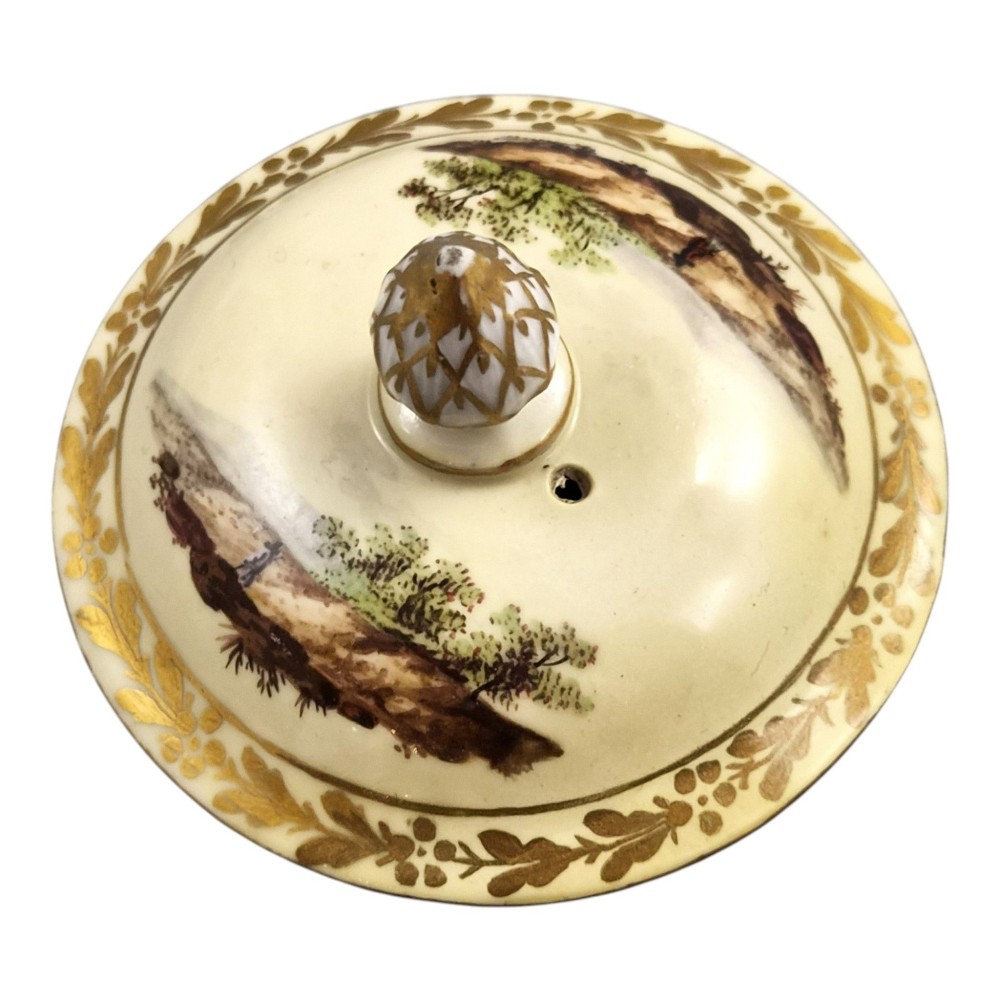 An 18th-century Furstenberg porcelain coffee pot featuring a hand-painted Neoclassical landscape, gold-leaf foliage rim, and an angular gilded handle with a pinecone finial lid. View XIII