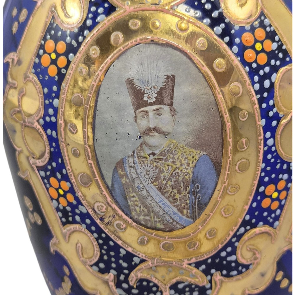 A cobalt blue Bohemian glass decanter decorated with elaborate gold enamelling and a painted portrait medallion, featuring a tall pointed stopper. View IX