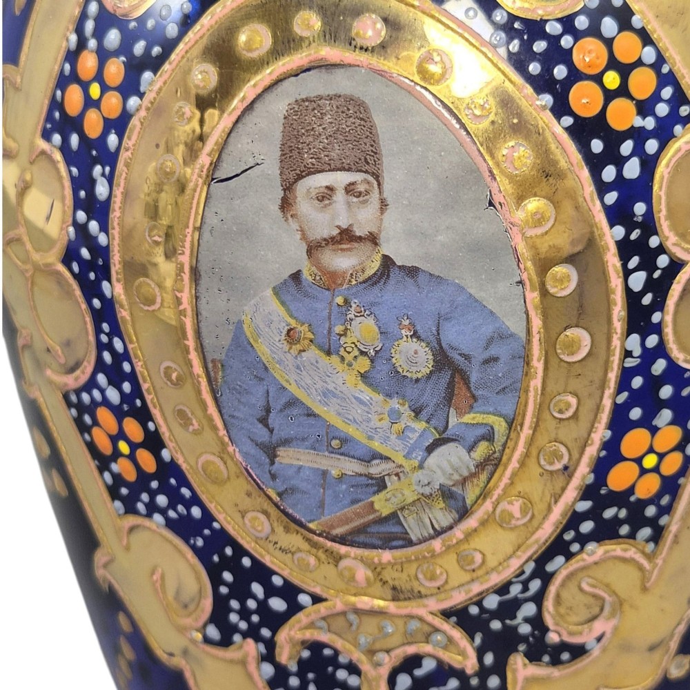 A cobalt blue Bohemian glass decanter decorated with elaborate gold enamelling and a painted portrait medallion, featuring a tall pointed stopper. View X