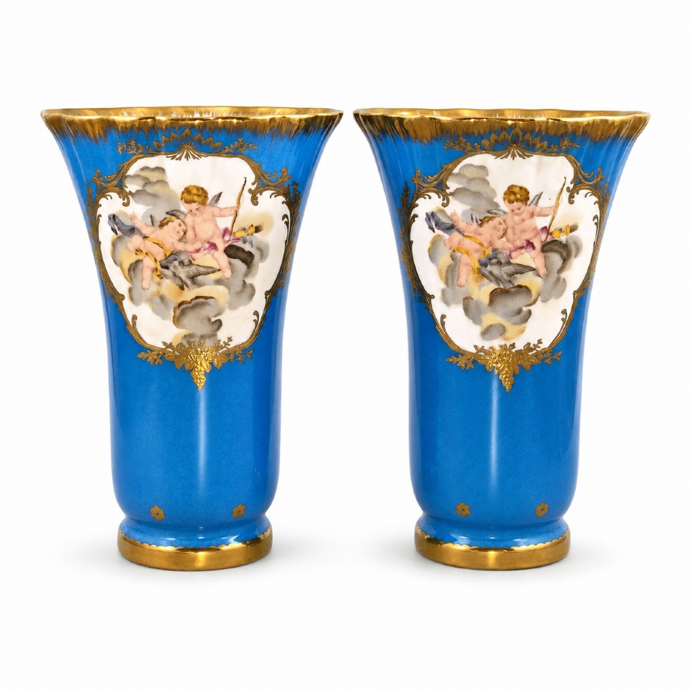 A pair of 19th-century French turquoise blue porcelain vases featuring hand-painted cherub reserves and gilded borders.