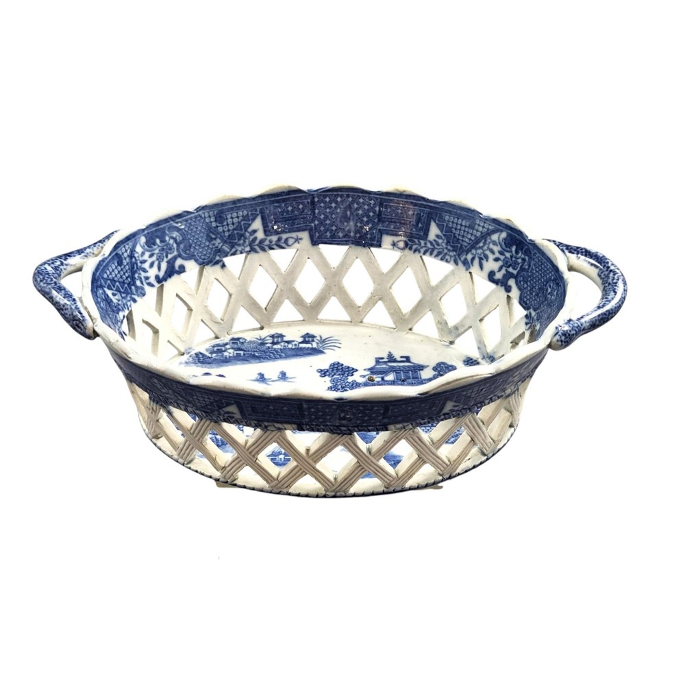 A Regency period blue and white transfer-printed ceramic chestnut basket featuring openwork reticulated lattice sides and two loop side handles. View II