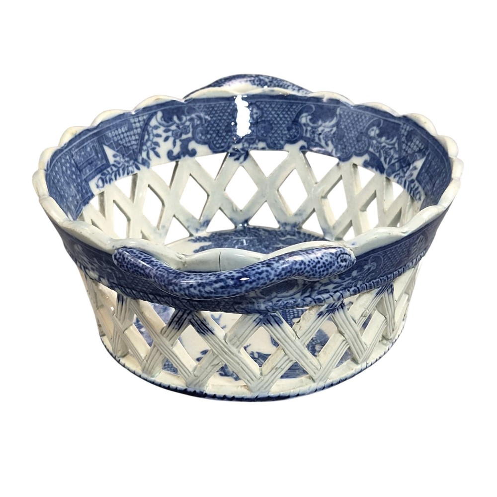 A Regency period blue and white transfer-printed ceramic chestnut basket featuring openwork reticulated lattice sides and two loop side handles. View V