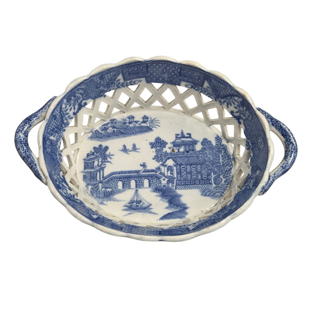A Regency period blue and white transfer-printed ceramic chestnut basket featuring openwork reticulated lattice sides and two loop side handles. View VII