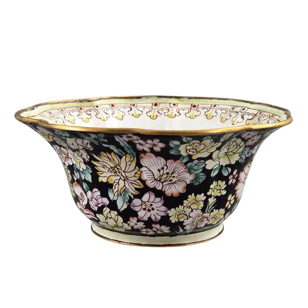 A Chinese Canton enamel-on-copper bowl featuring a lobed rim, a black ground exterior decorated with colourful floral motifs, and a white interior with a patterned border. View II