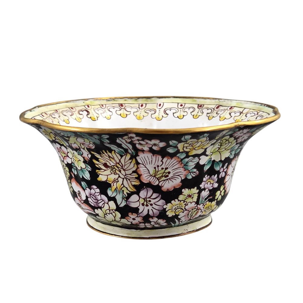 A Chinese Canton enamel-on-copper bowl featuring a lobed rim, a black ground exterior decorated with colourful floral motifs, and a white interior with a patterned border. View IV