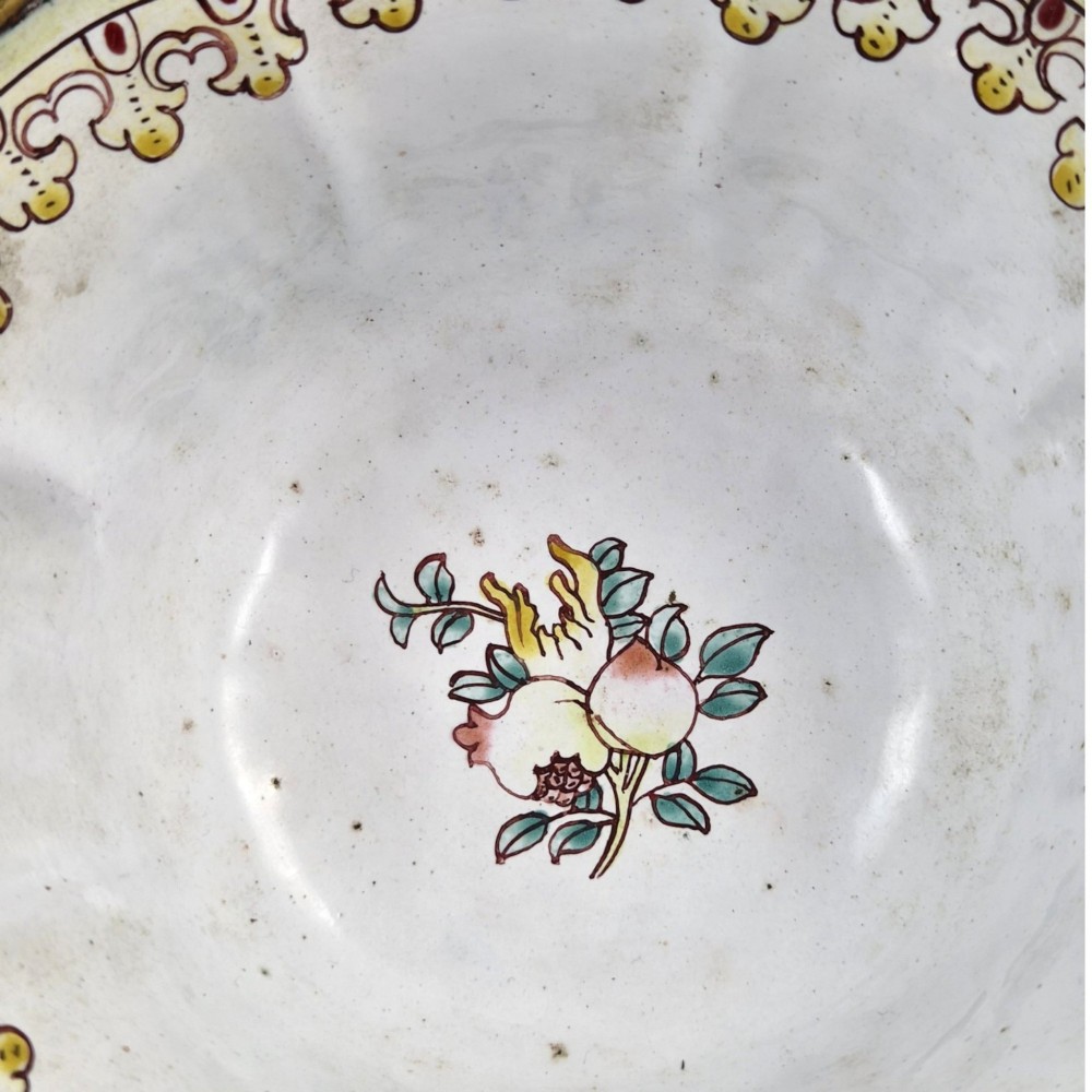 A Chinese Canton enamel-on-copper bowl featuring a lobed rim, a black ground exterior decorated with colourful floral motifs, and a white interior with a patterned border. View VII