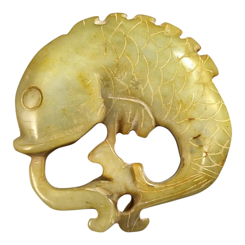 A group of three carved Chinese stone amulets featuring a carp, a central circular bi disc with a qilin, and a chilong dragon. View II