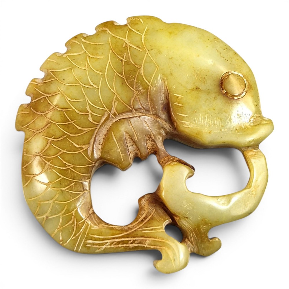 A group of three carved Chinese stone amulets featuring a carp, a central circular bi disc with a qilin, and a chilong dragon. View X