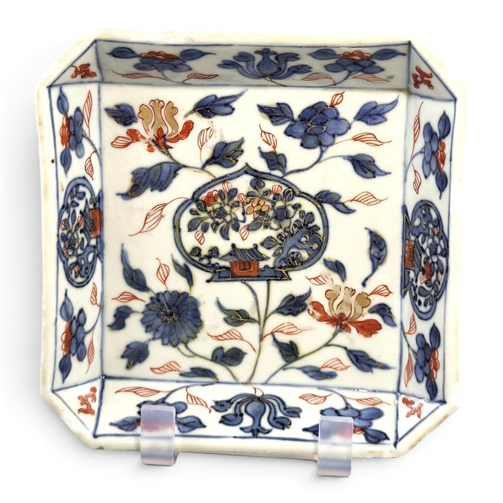 A Chinese Imari porcelain chamfered square bowl decorated with underglaze blue and overglaze red floral motifs from the Kangxi period.