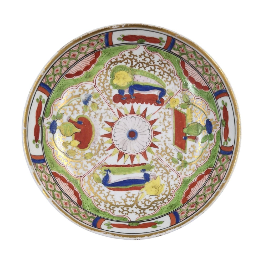 A Regency period Worcester porcelain coffee cup and matching saucer decorated in the hand-painted Dragon in Compartments pattern with green, red, blue, and gilt detailing. View II